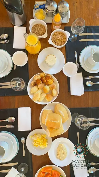 Mesa do café da manhã com sucos, frutas e pães