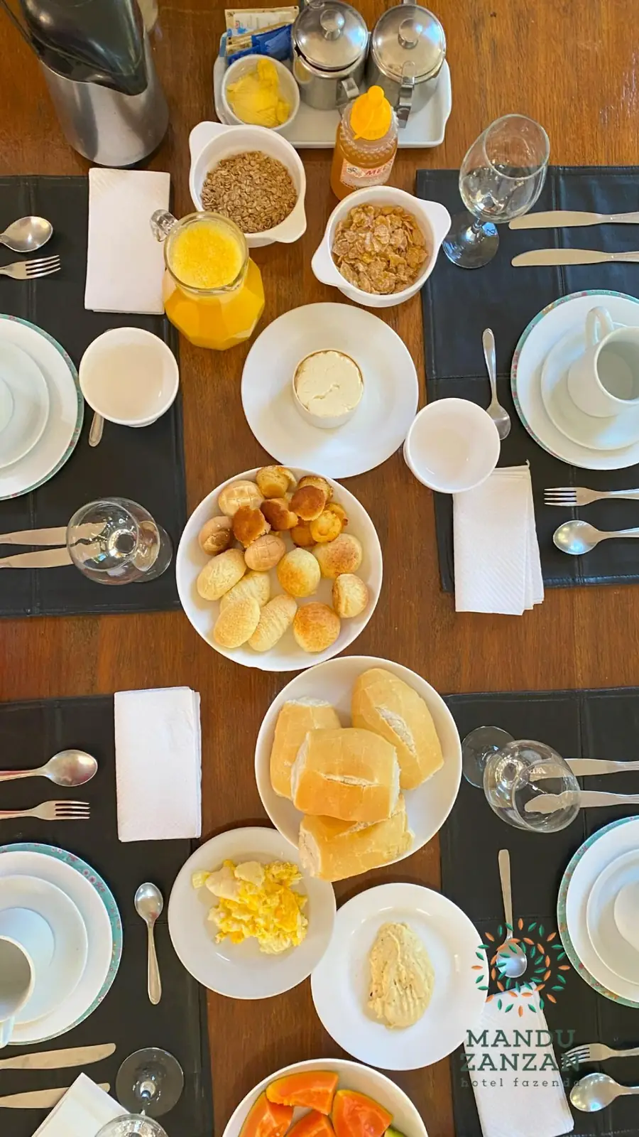 Mesa do café da manhã com sucos, frutas e pães