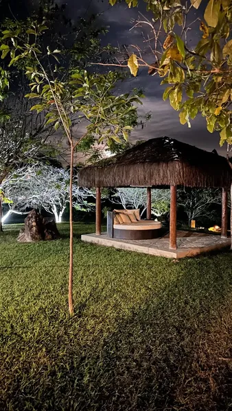 Quiosque de palha com daybed iluminado à noite